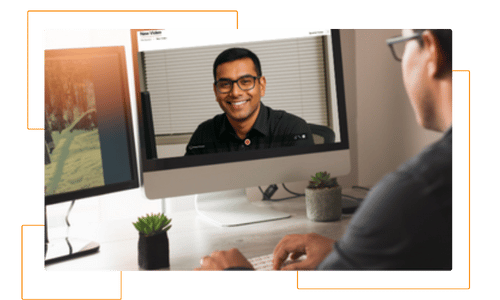 Smiling man recording a video on his computer